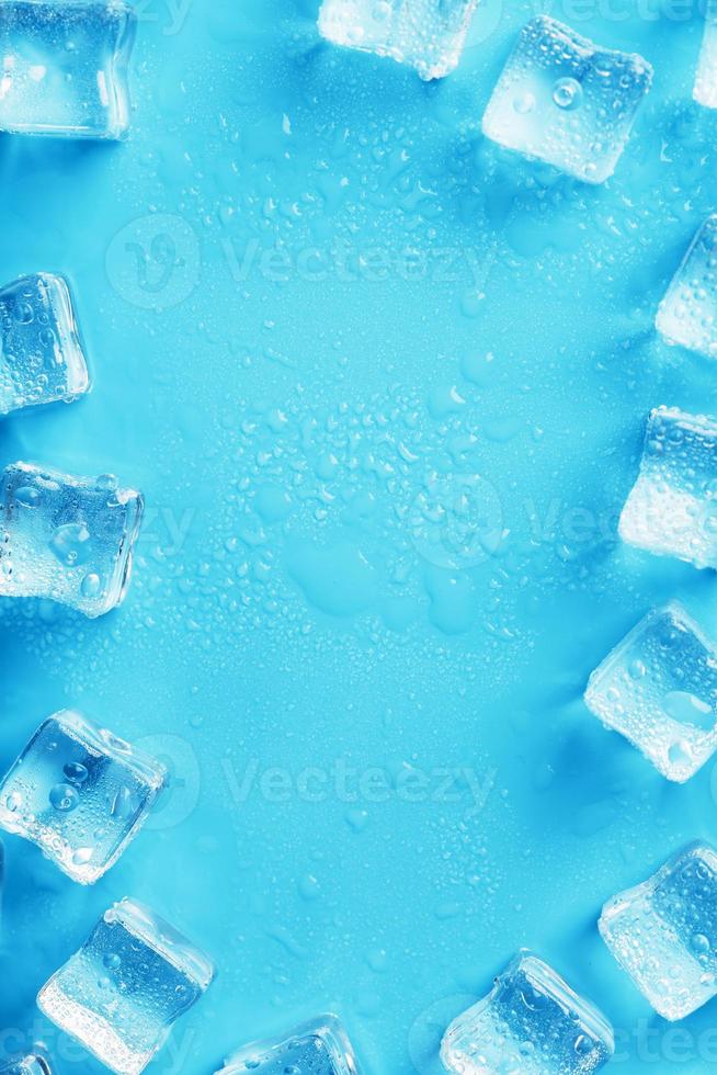 glace faite de cubes alignés avec des gouttes sur fond bleu avec espace libre photo