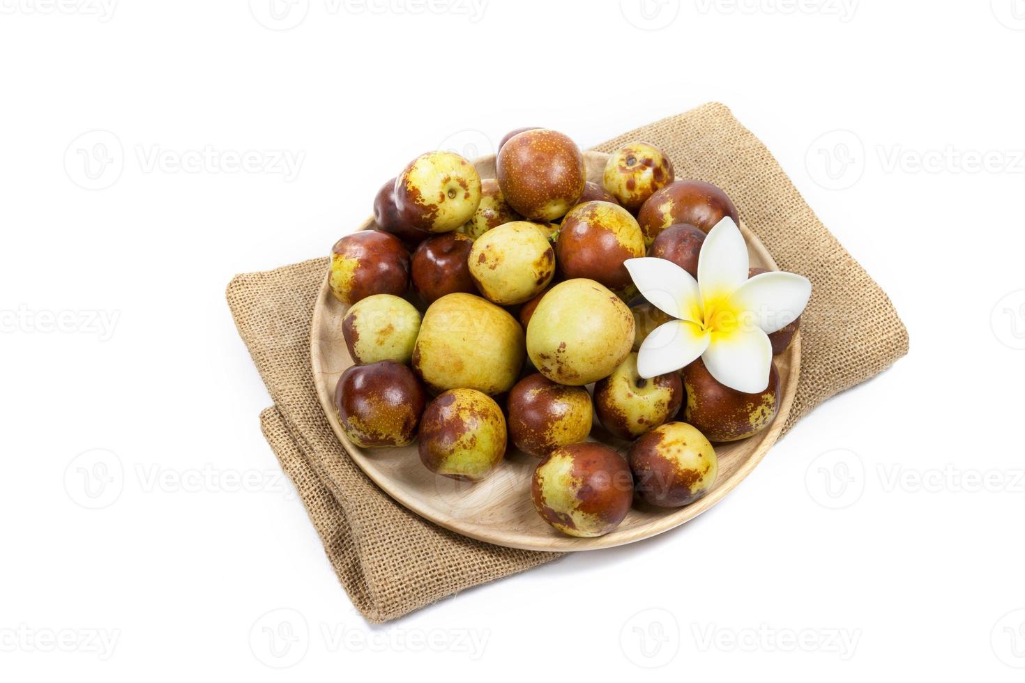 Jujube chinois sur plaque de bois, isolé sur fond blanc photo