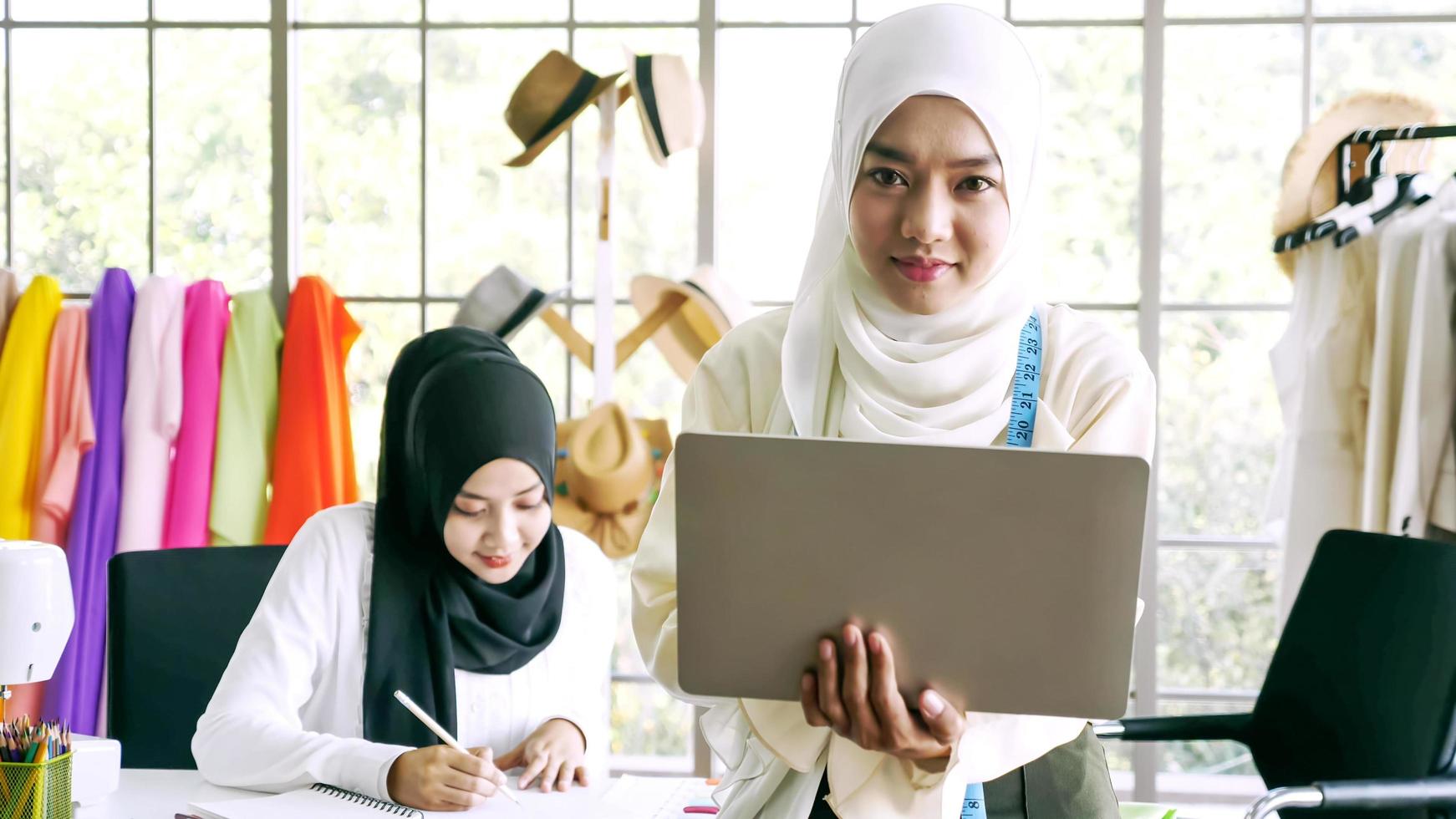 femmes musulmanes heureuses travaillant ensemble au bureau de vêtements. photo