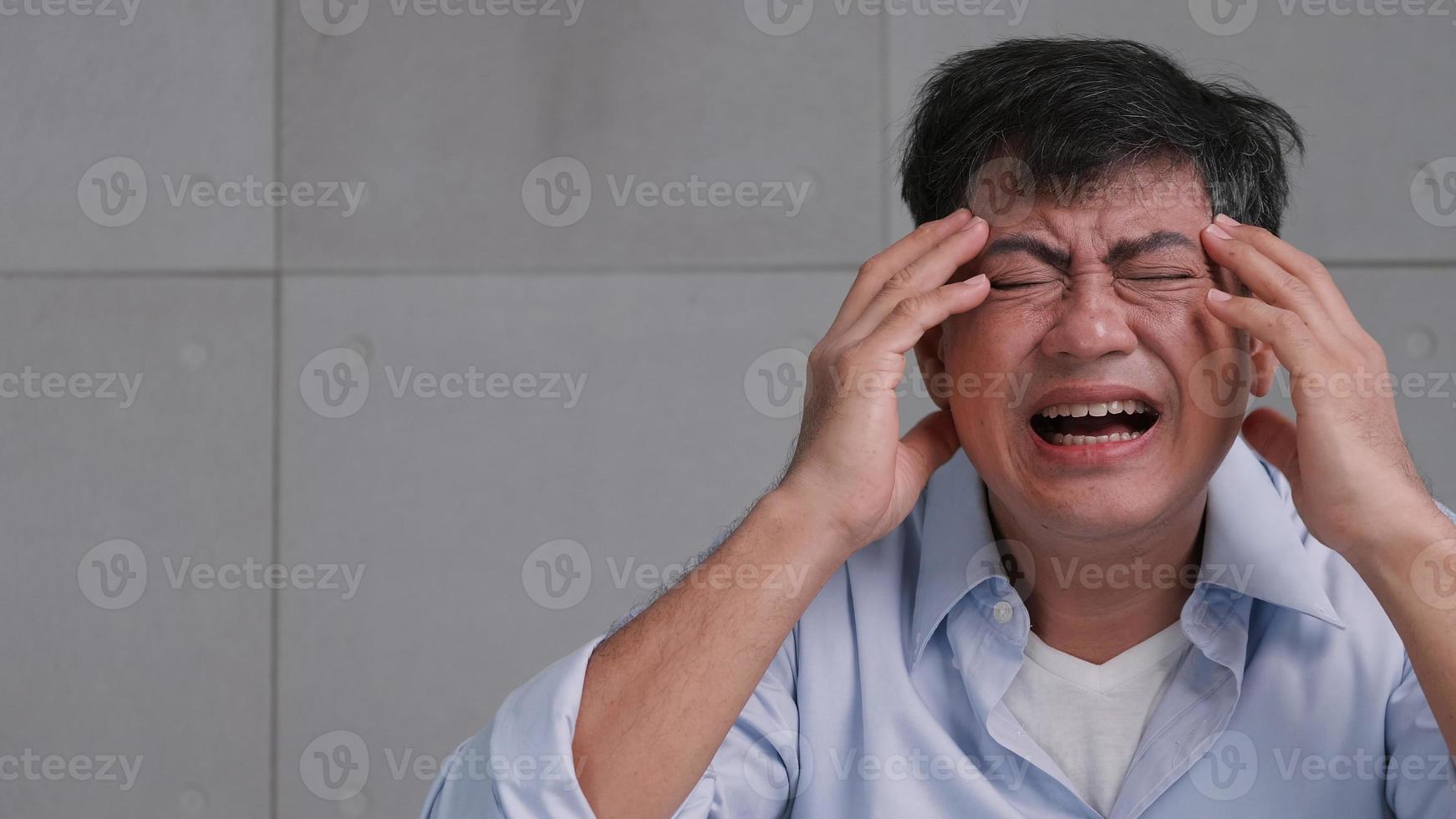 vieil homme asiatique souffrant de migraine. l'homme se sent stressé et inquiet des problèmes de santé. photo