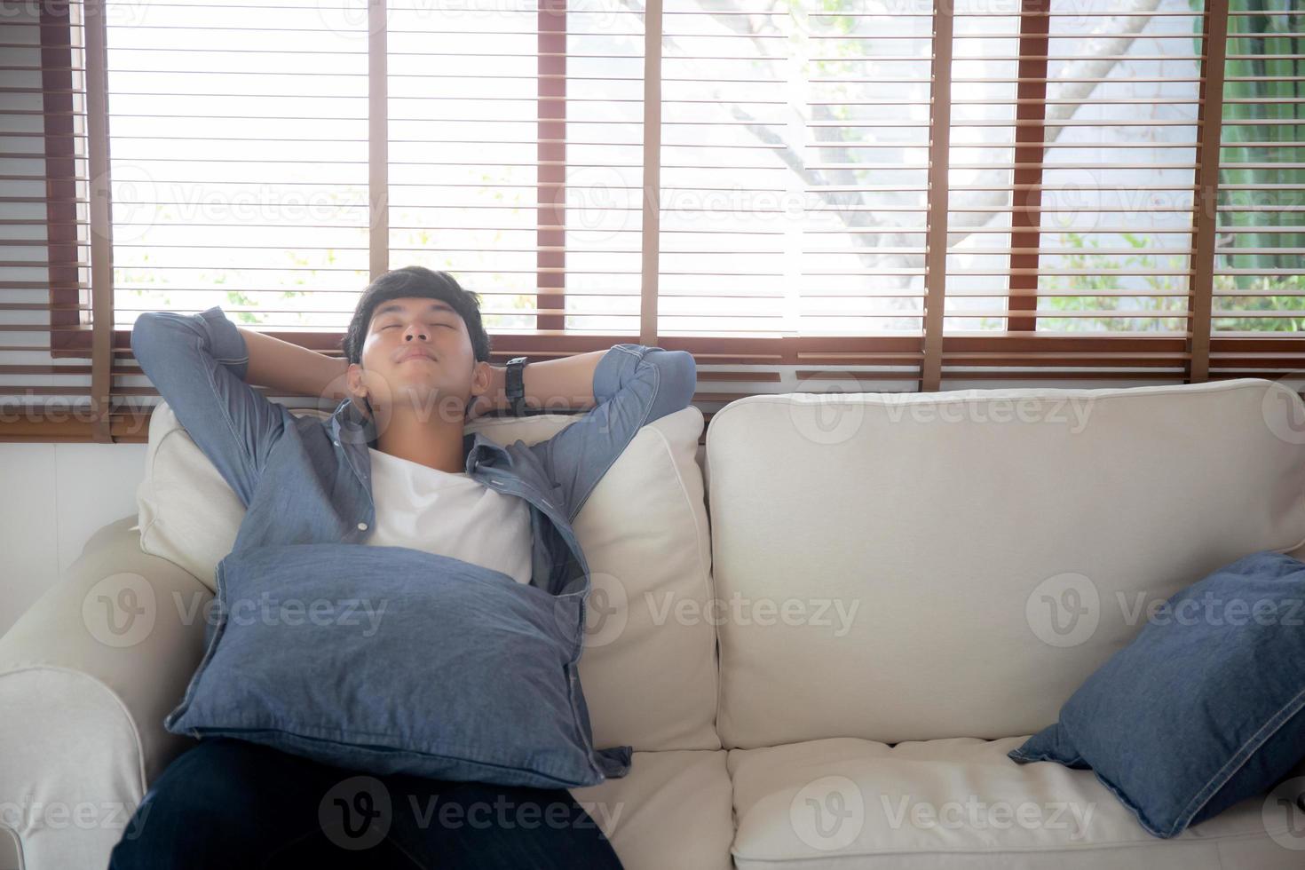 portrait jeune bel homme asiatique faisant la sieste se détendre avec confortable sur le canapé à la maison, homme d'asie se reposer et dormir le week-end avec fatigué et paresseux sur le canapé en vacances, style de vie et concept de bien-être. photo