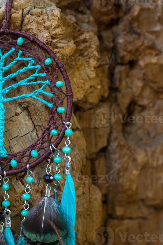 attrape-rêves fait à la main avec des fils de plumes et des cordes de perles suspendues photo