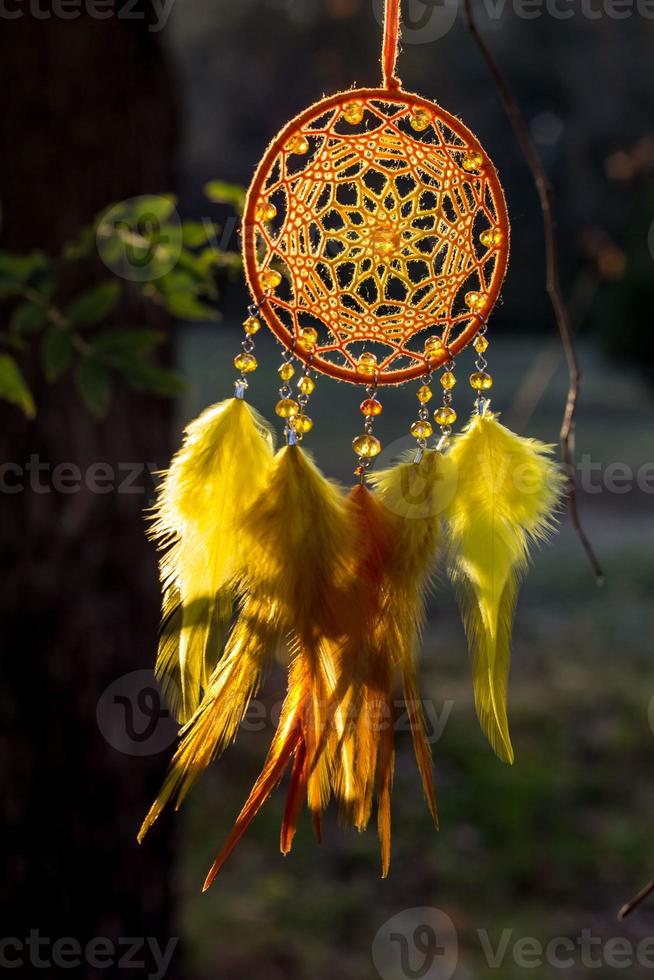 attrape-rêves fait à la main avec des fils de plumes et des cordes de perles suspendues photo