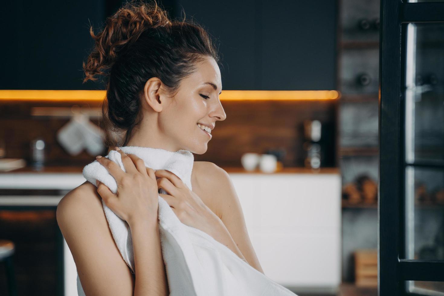 routine beauté du matin. une fille européenne heureuse essuie le visage avec une serviette douce après le lavage. photo