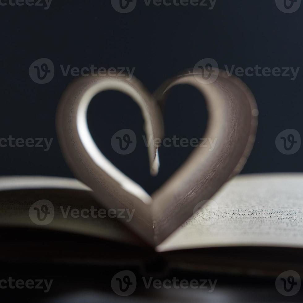 un roman d'amour. livre ouvert gros plan flou. les pages sont disposées en forme de cœur sur fond gris dans un flou. photo