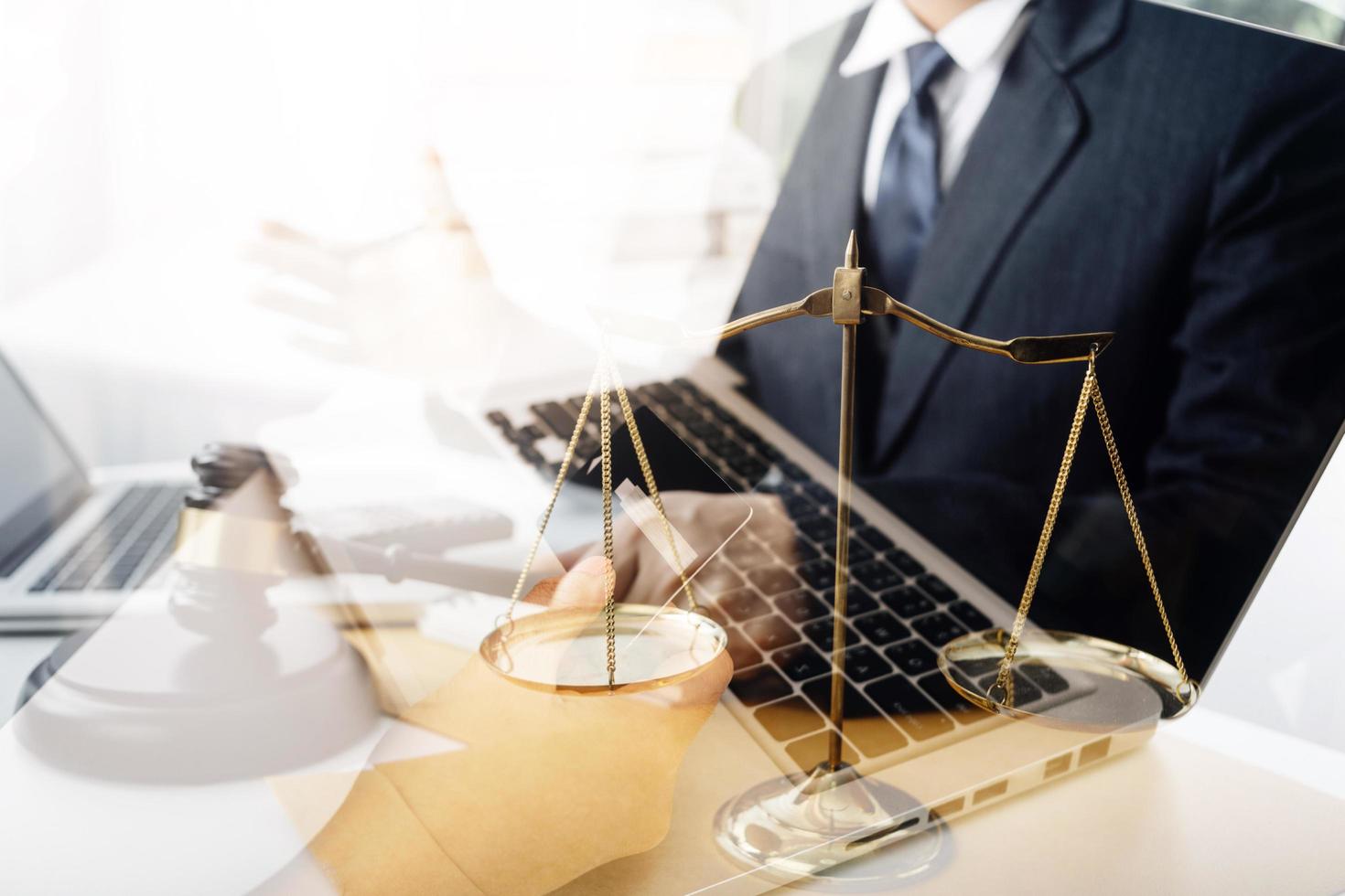 concept de justice et de droit. juge masculin dans une salle d'audience avec le marteau, travaillant avec, clavier d'ordinateur et d'accueil, lunettes, sur table à la lumière du matin photo