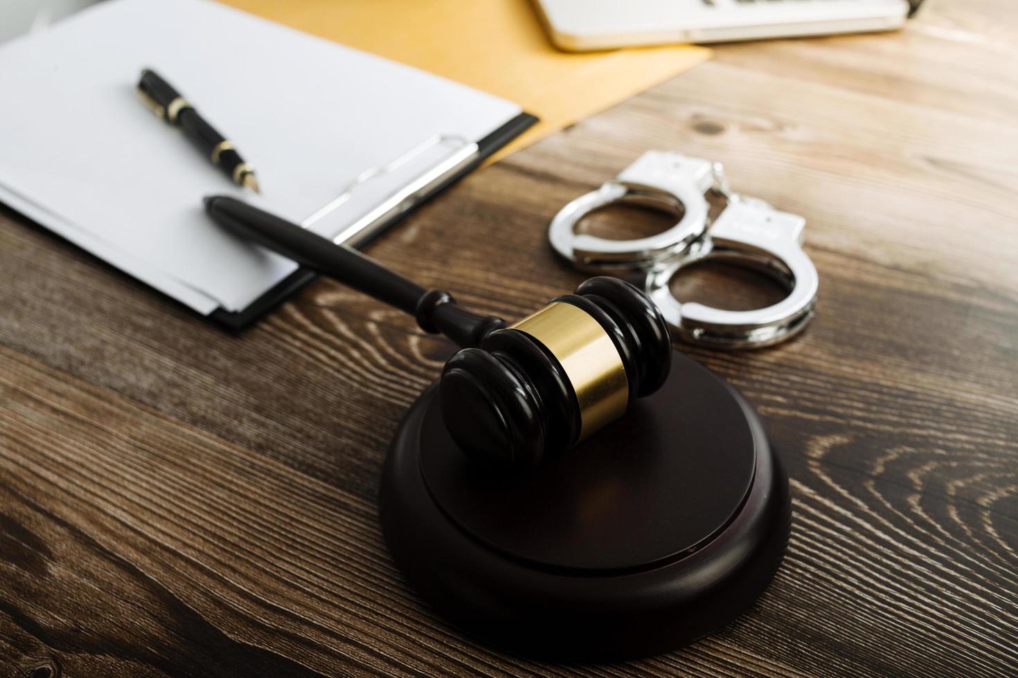 concept de justice et de droit. juge masculin dans une salle d'audience avec le marteau, travaillant avec, clavier d'ordinateur et d'accueil, lunettes, sur table à la lumière du matin photo