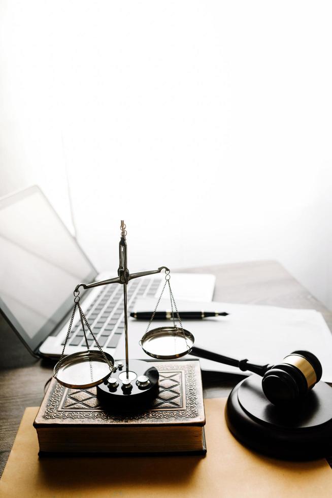 concept de justice et de droit. juge masculin dans une salle d'audience avec le marteau, travaillant avec, clavier d'ordinateur et d'accueil, lunettes, sur table à la lumière du matin photo