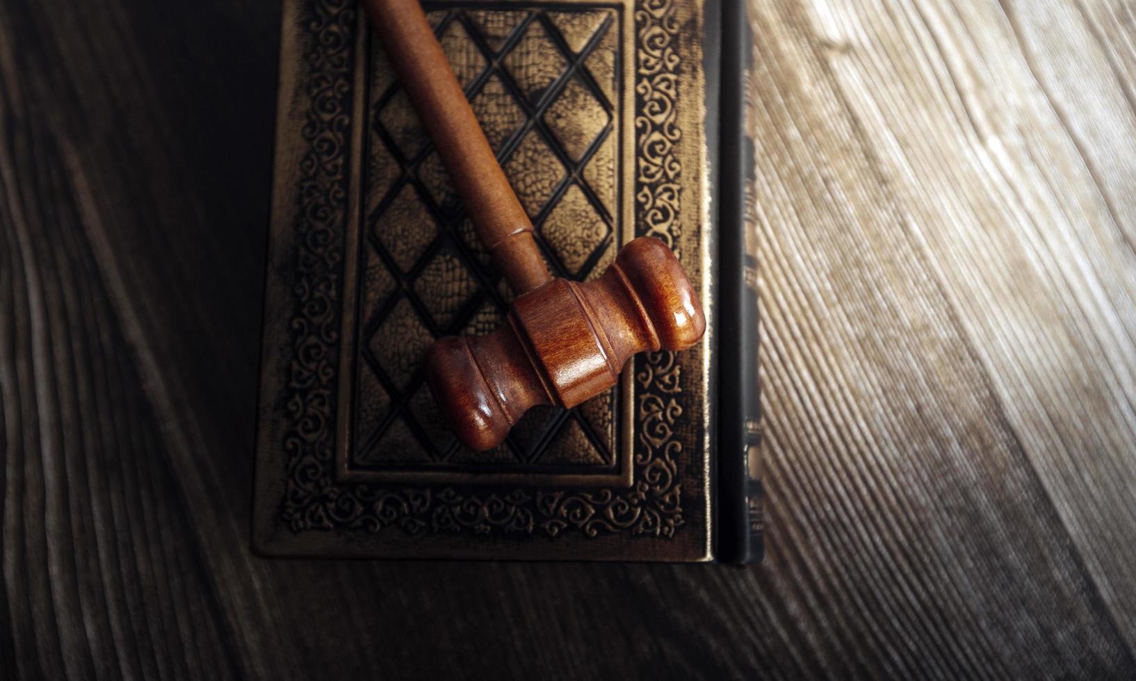 concept de justice et de droit. juge masculin dans une salle d'audience avec le marteau, travaillant avec, clavier d'ordinateur et d'accueil, lunettes, sur table à la lumière du matin photo