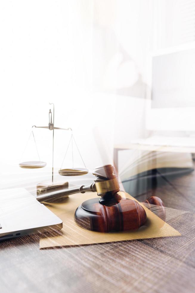 concept de justice et de droit. juge masculin dans une salle d'audience avec le marteau, travaillant avec, clavier d'ordinateur et d'accueil, lunettes, sur table à la lumière du matin photo