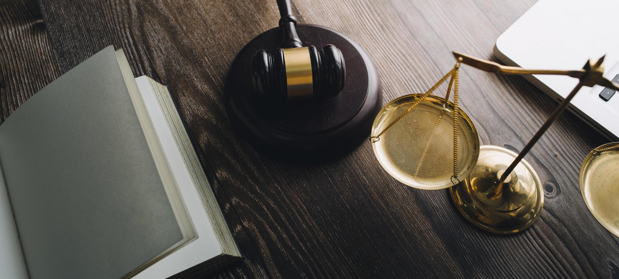 concept de justice et de droit. juge masculin dans une salle d'audience avec le marteau, travaillant avec, clavier d'ordinateur et d'accueil, lunettes, sur table à la lumière du matin photo