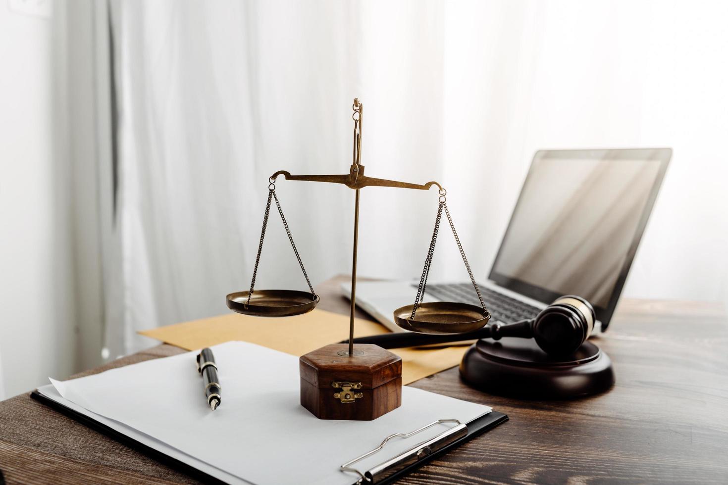 concept de justice et de droit. juge masculin dans une salle d'audience avec le marteau, travaillant avec, clavier d'ordinateur et d'accueil, lunettes, sur table à la lumière du matin photo