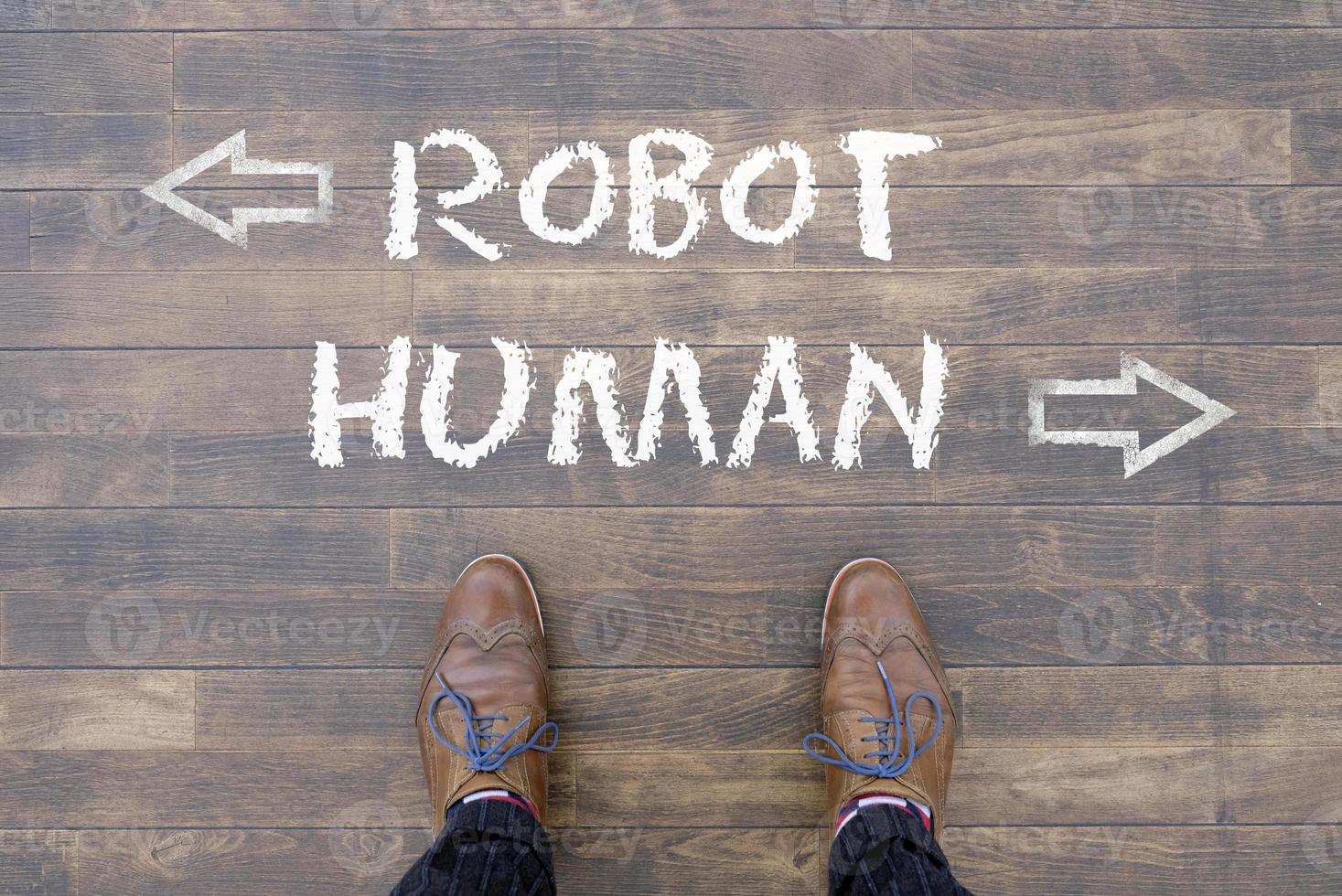 homme regardant les mots robot et humain écrits à la craie sur le sol photo
