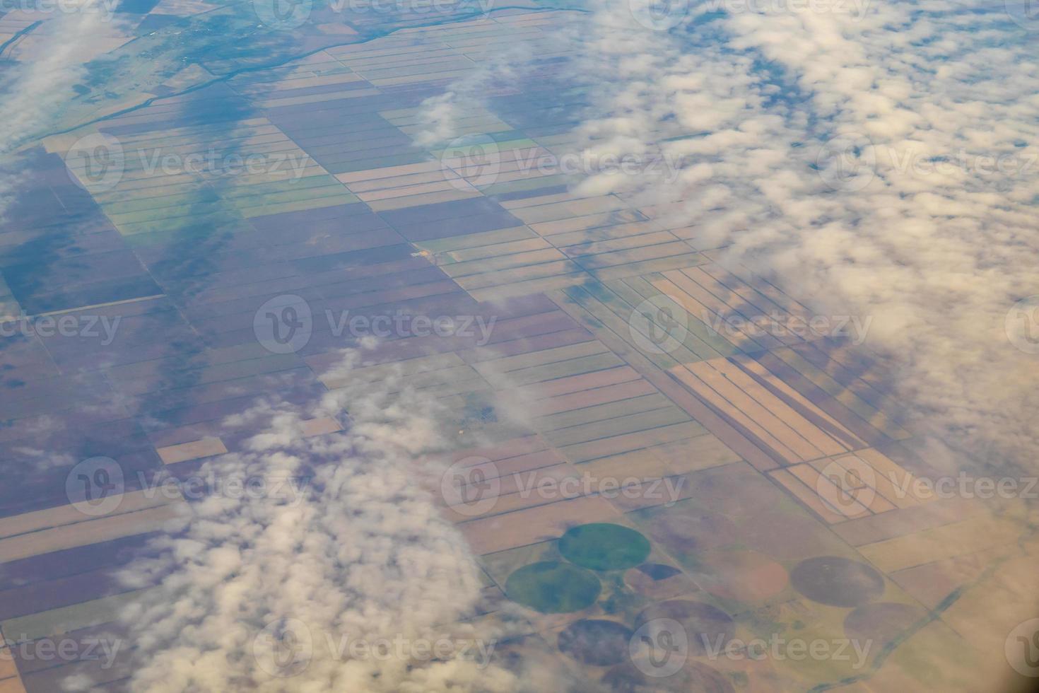 photo aérienne de terres agricoles. vue de l'avion au sol. carrés de champs sous les nuages