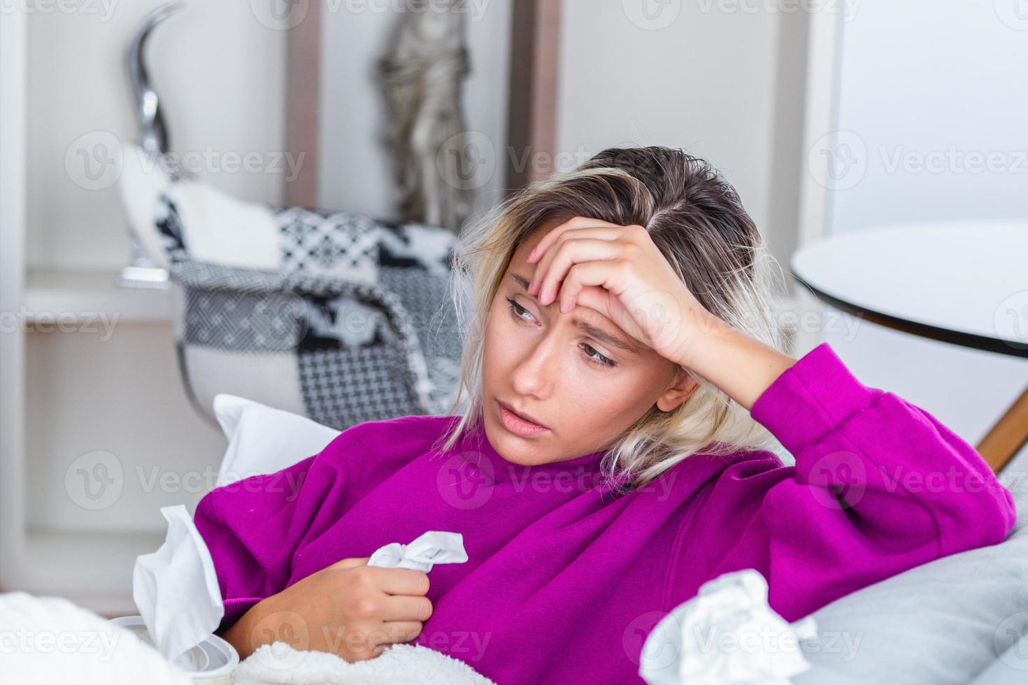 femme malade avec des maux de tête assis sous la couverture. femme malade avec des infections saisonnières, grippe, allergie au lit. femme malade recouverte d'une couverture allongée dans son lit avec une forte fièvre et une grippe, se reposant. photo