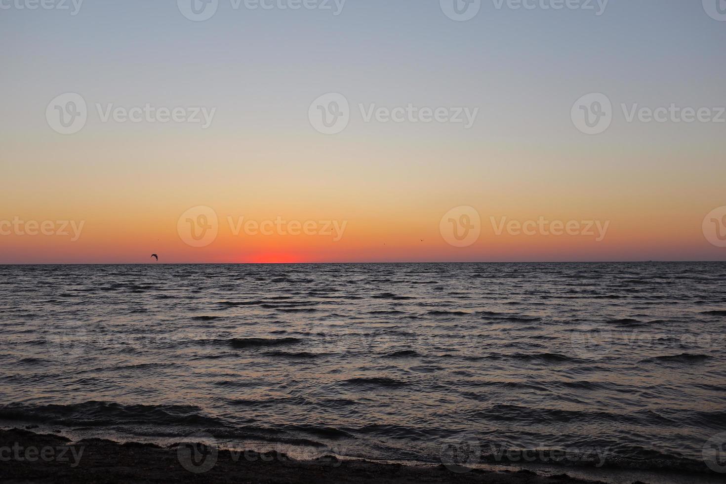 coucher de soleil doré ou lever de soleil sur l'océan sombre et profond. vue aérienne du coucher du soleil et jusqu'à la mer. ciel coloré jaune et orange. beau ciel romantique au printemps. photo