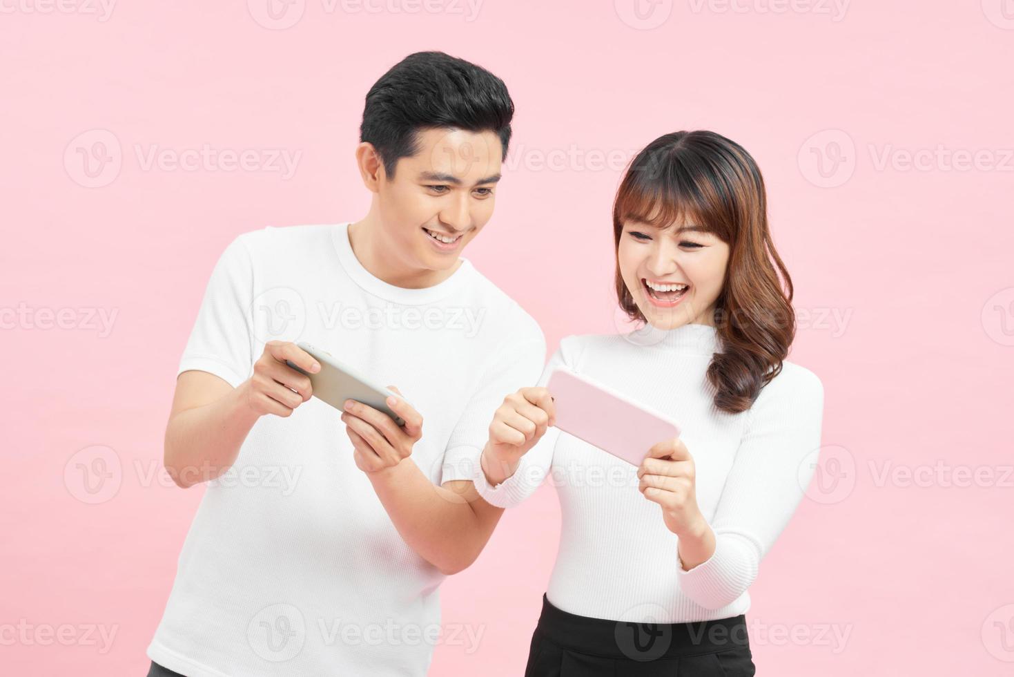 jeune couple avec des téléphones portables sur un fond de couleur photo
