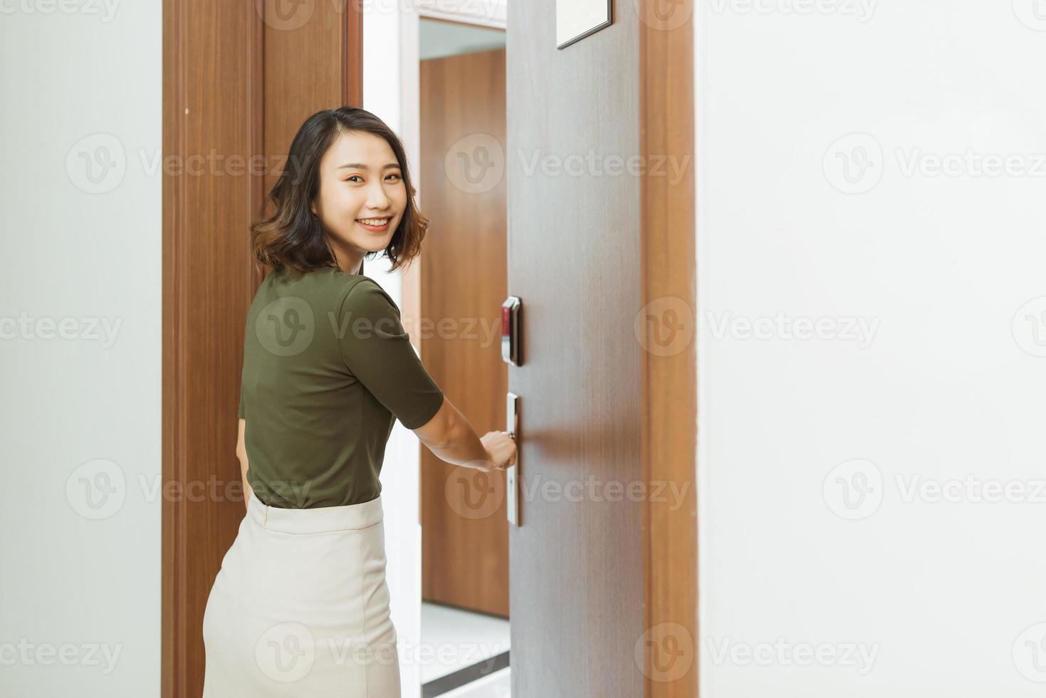 femme main tenant des poignées de porte modernes serrure électronique ouvrir la porte de l'appartement photo