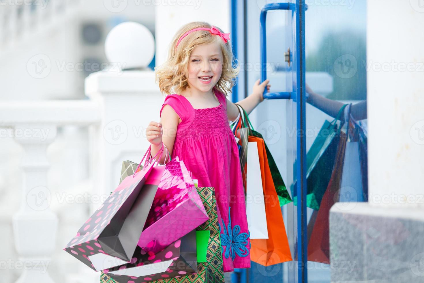 petite fille avec des sacs à provisions va au magasin photo