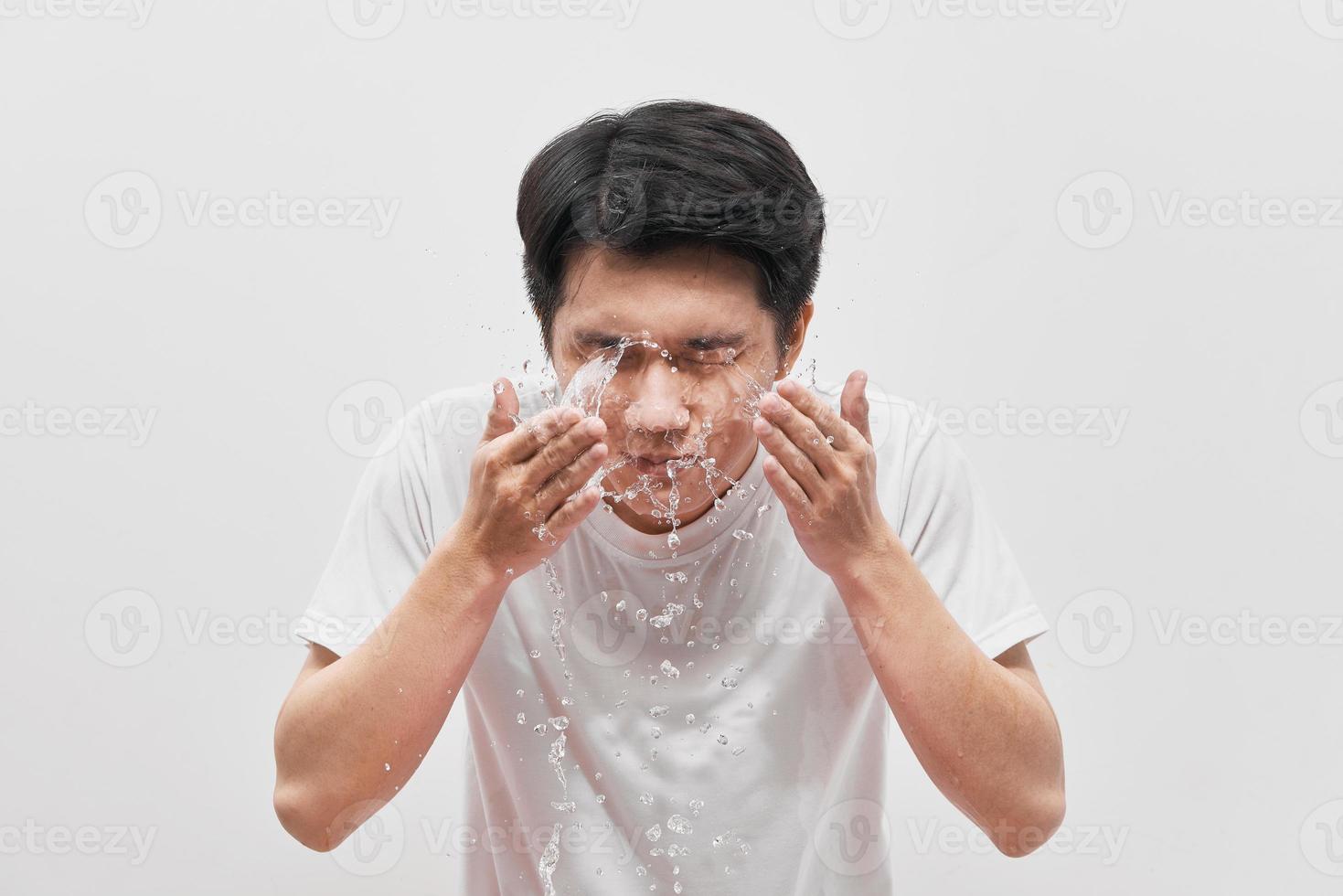 bel homme fait la vaisselle, éclaboussures d'eau, sur fond blanc photo