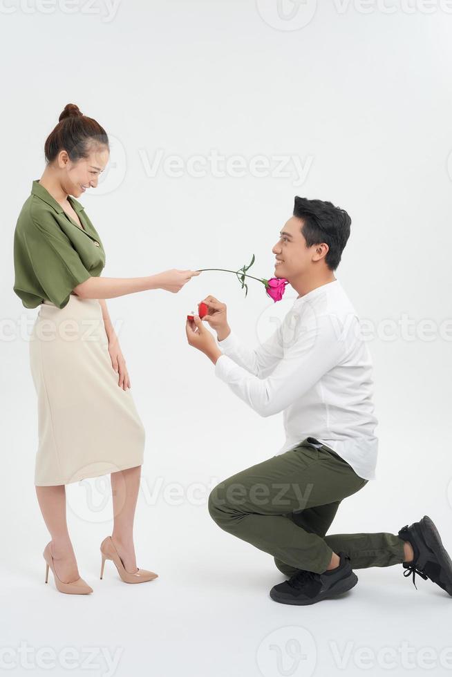 jeune homme à genoux proposant à sa petite amie photo