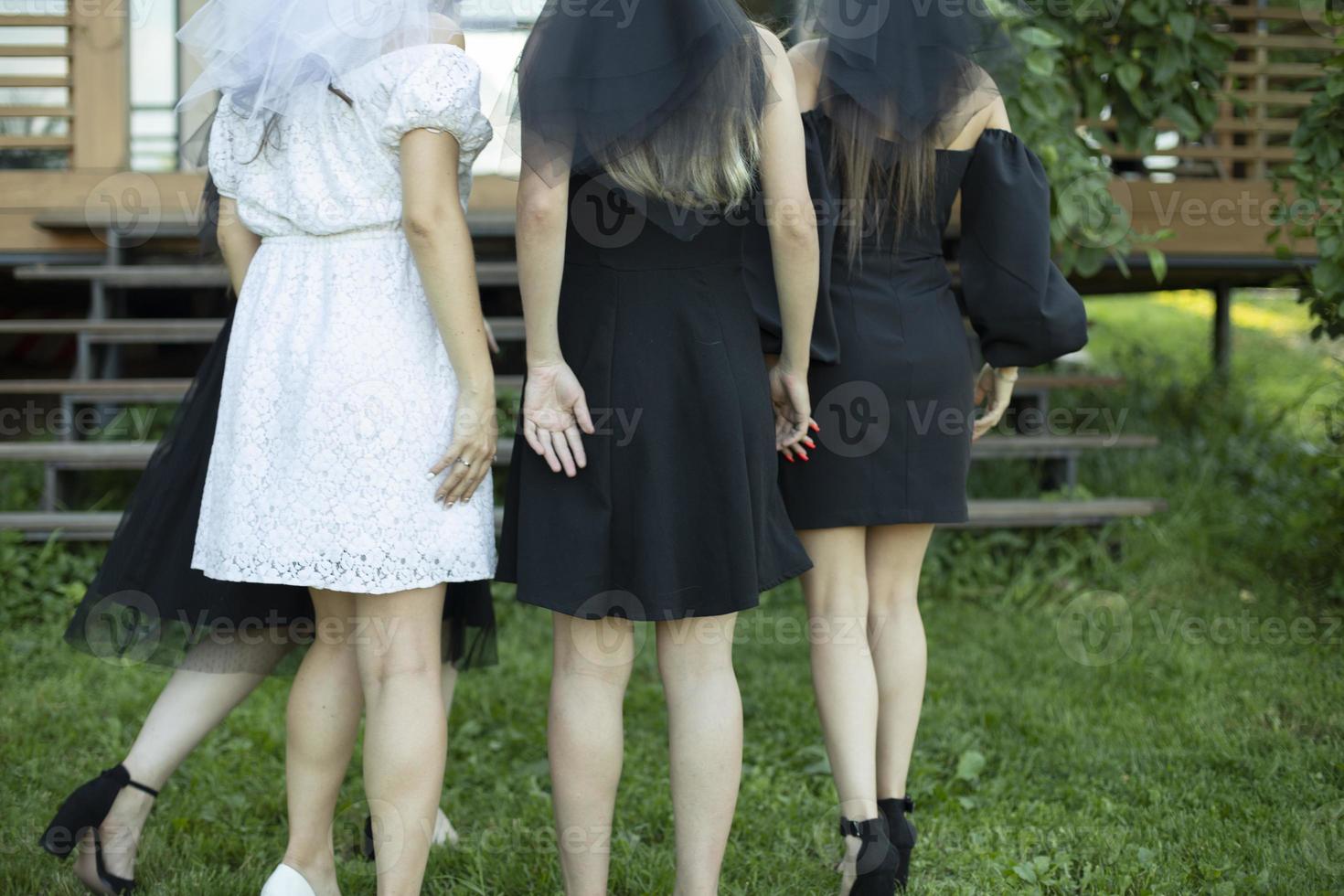 fille à la fête. filles en robes noires. mariée avec des demoiselles d'honneur par derrière. photo