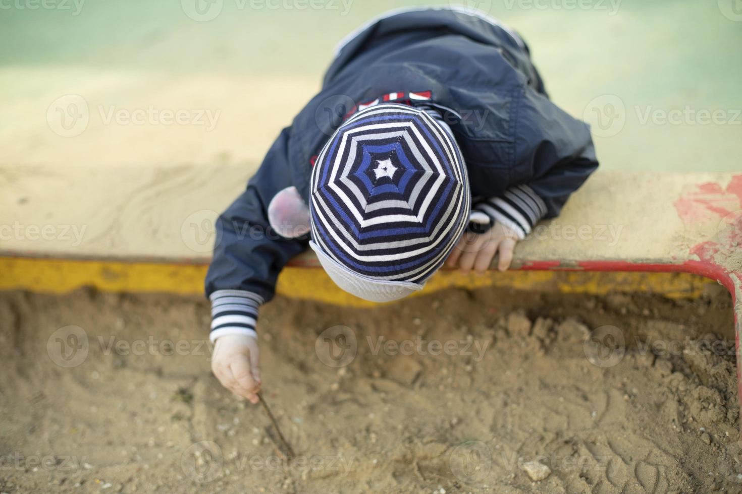 enfant dans le bac à sable. enfant d'âge préscolaire sur l'aire de jeux. photo