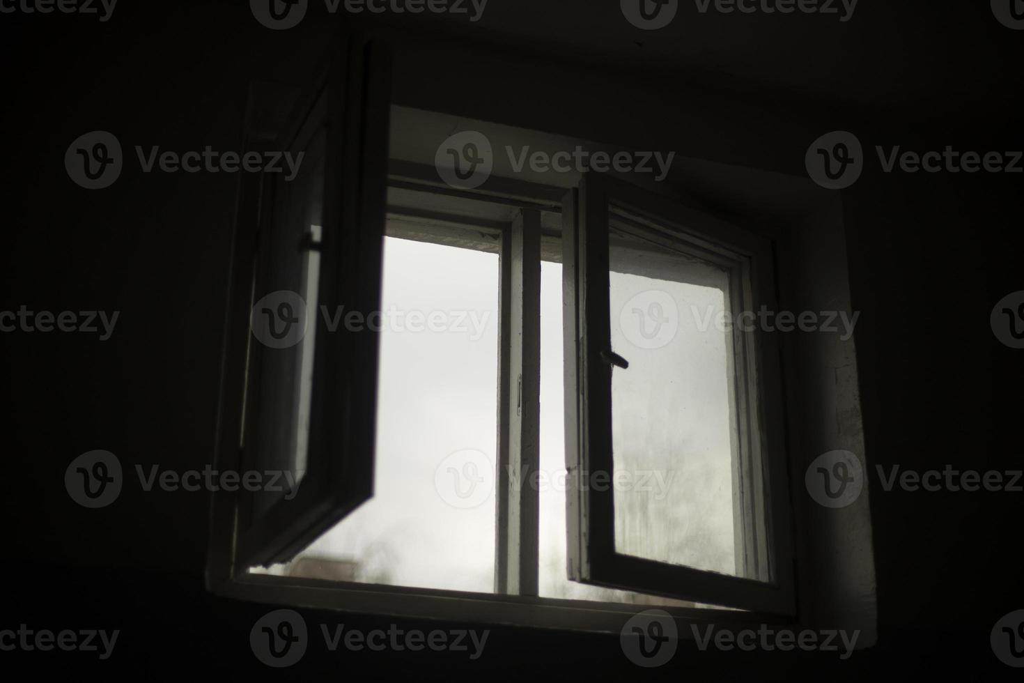 la fenêtre est dans le noir. fenêtre ouverte dans le bâtiment. photo