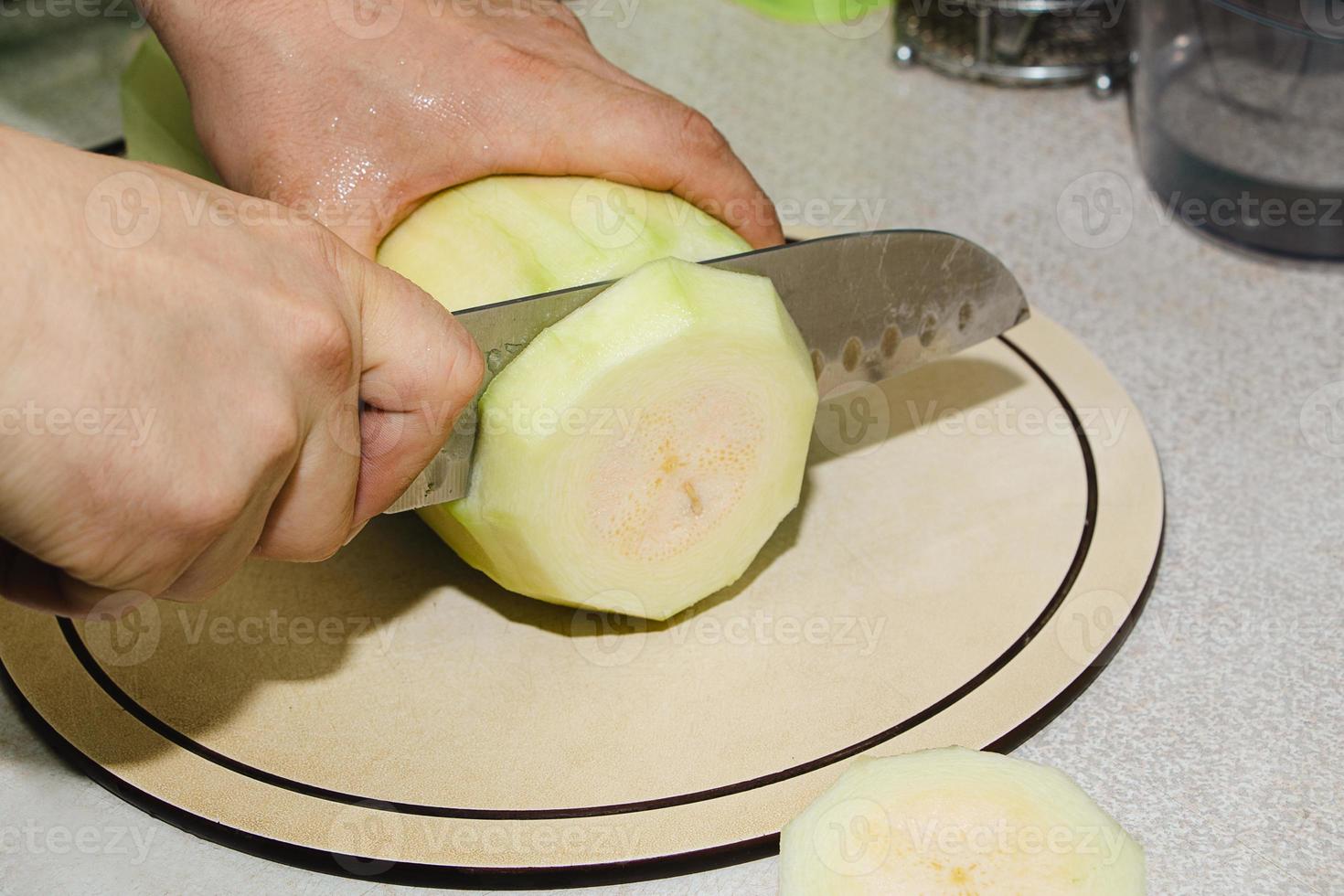 recette de beignets de courgettes. étape 2 - couper les courgettes. les mains coupent les courgettes vertes en cubes. photo