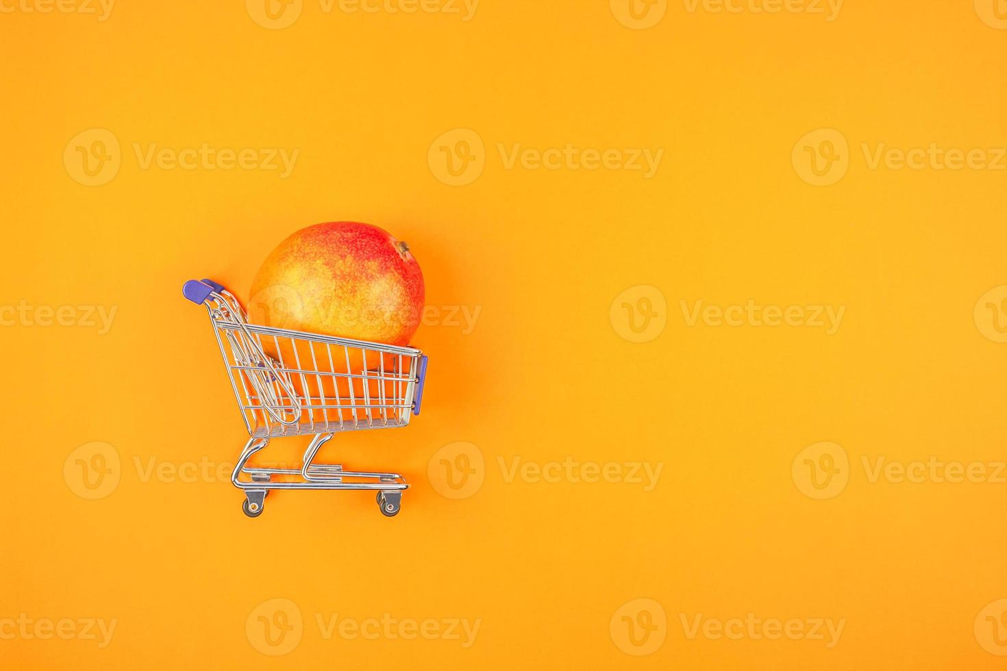 mangue dans le panier sur fond orange photo
