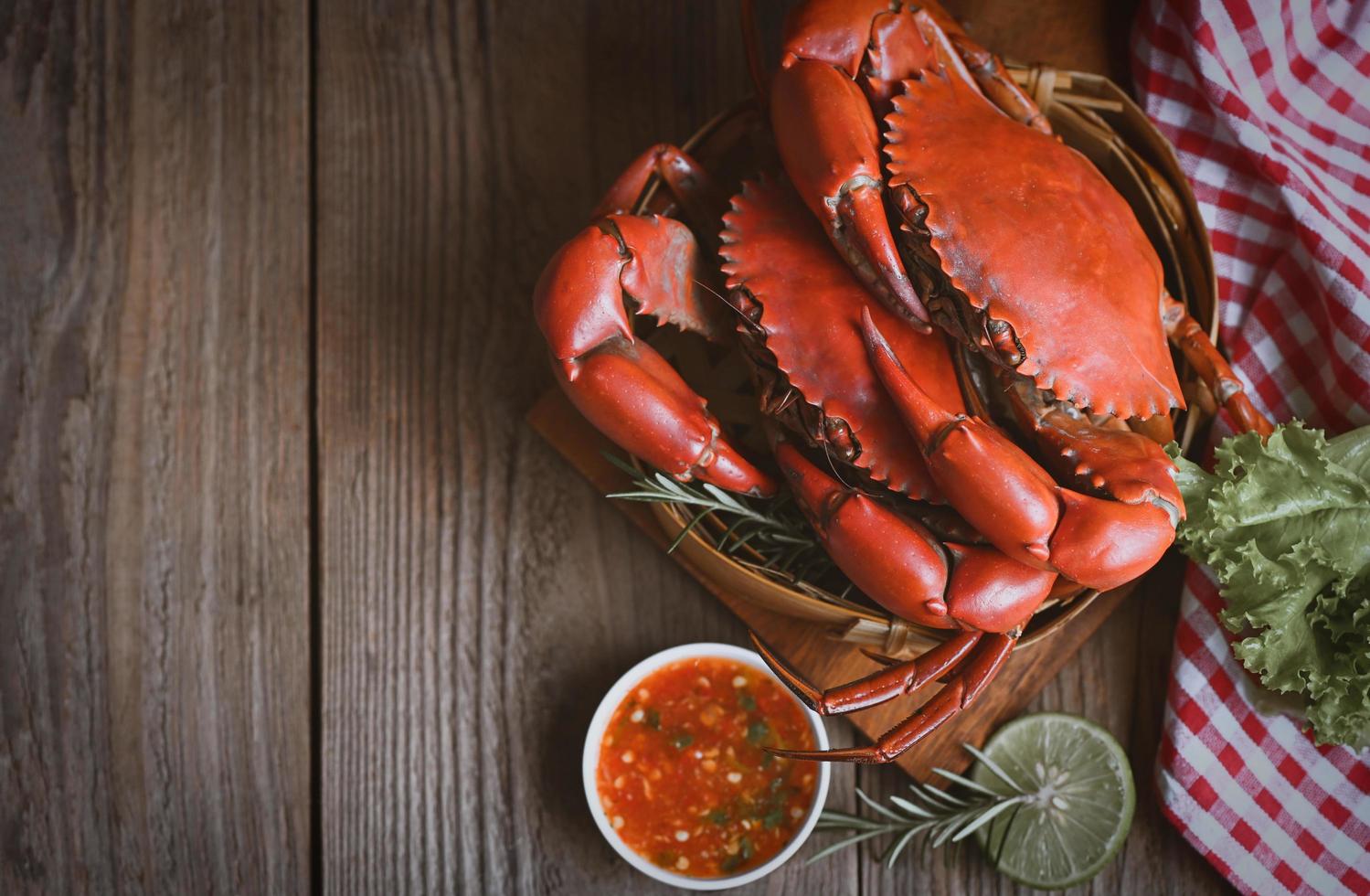 crabe frais sur une planche à découper en bois, crabe de fruits de mer cuisson des aliments crabe bouilli ou cuit à la vapeur rouge dans la cuisine du restaurant de fruits de mer photo
