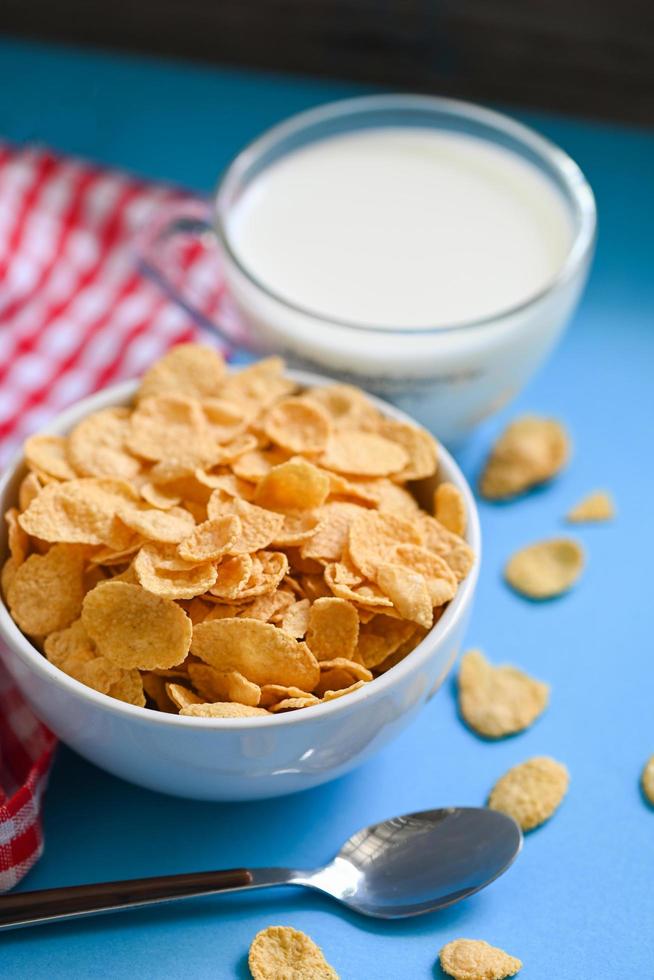 bol de cornflakes petit-déjeuner et collation pour un concept d'alimentation saine, petit-déjeuner matinal céréales complètes fraîches, cornflakes avec du lait sur fond bleu photo