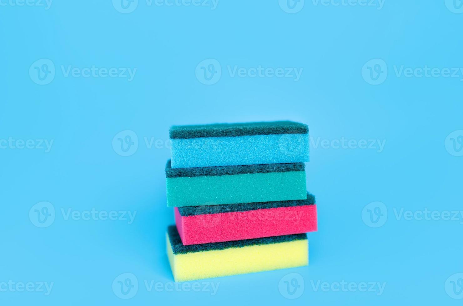 éponges multicolores pour le nettoyage sur fond bleu. espace pour le texte. photo