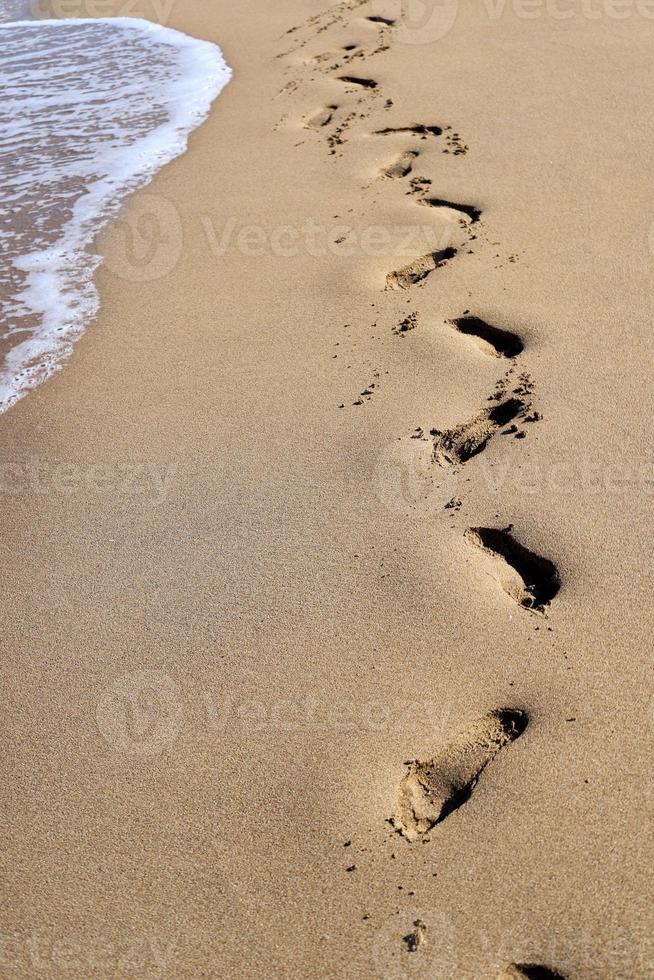 empreintes de pas dans le sable sur les rives de la mer méditerranée. photo