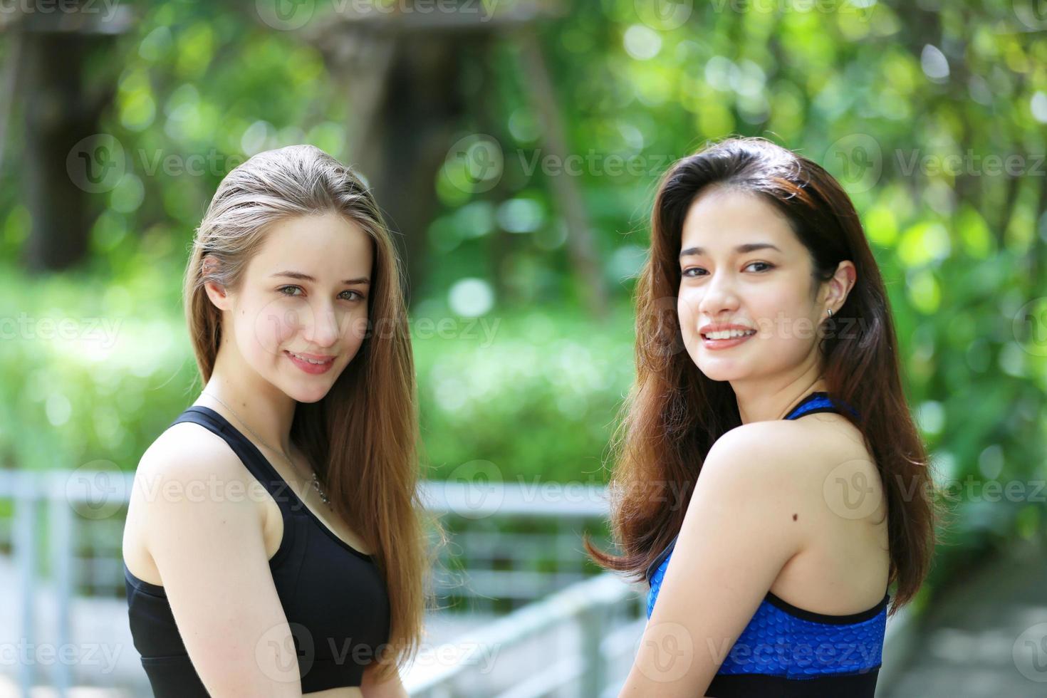 deux jeunes femmes séduisantes faisant des exercices de yoga étirants dans le parc. photo