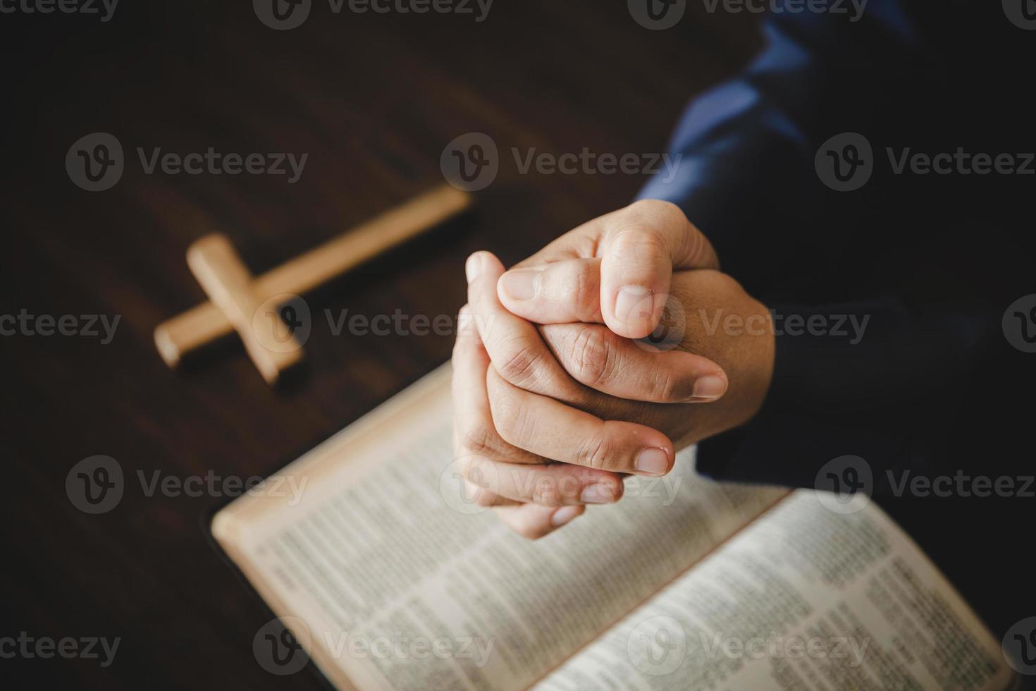 main pliée en prière à dieu sur le livre de la sainte bible dans le concept d'église pour la foi, la spiritualité et la religion, femme priant sur la sainte bible le matin. main de femme catholique chrétienne avec culte biblique. photo