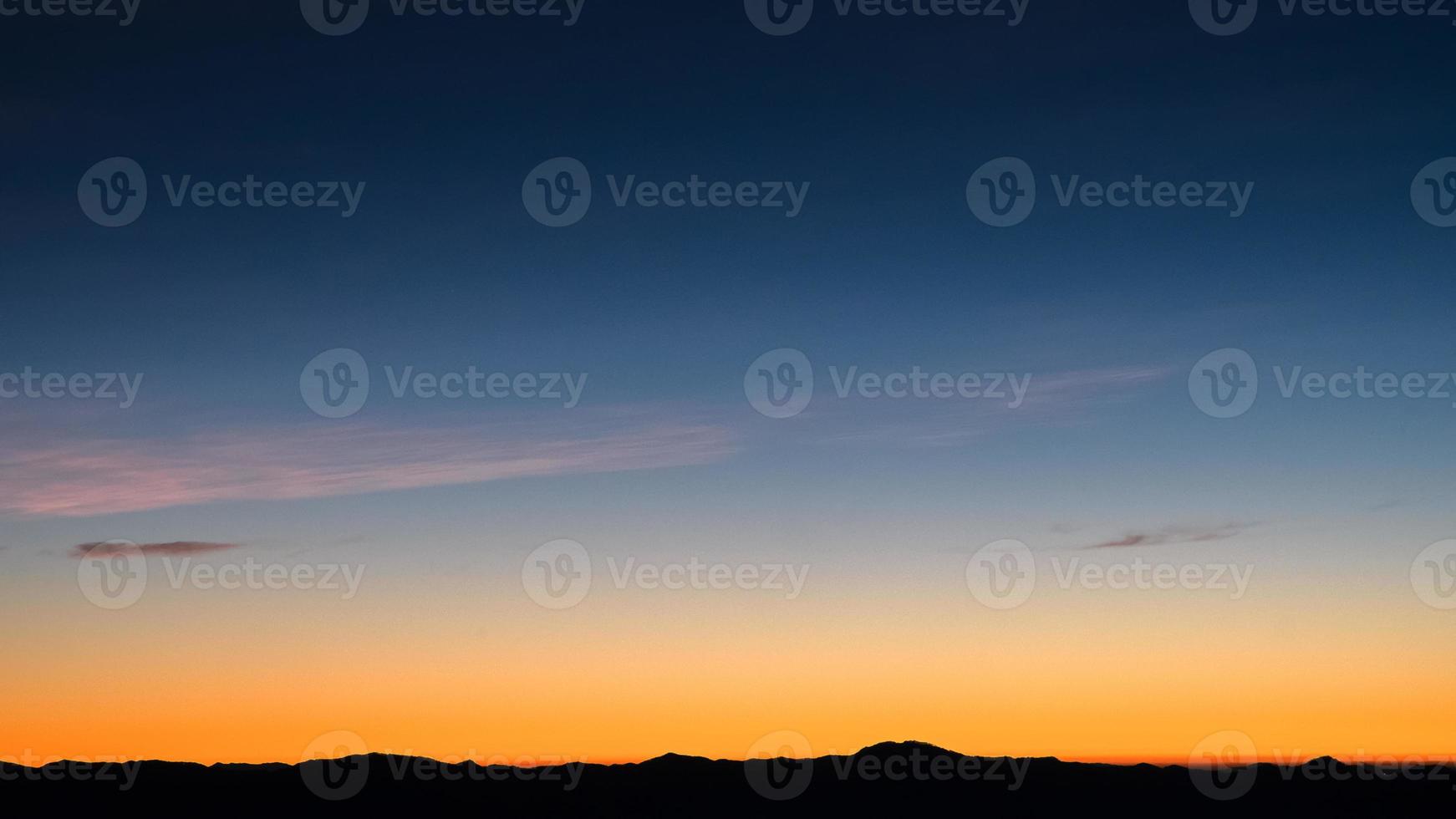 beau ciel nuageux lumineux avec lumière pour le fond de la religion du ciel. le paysage nuageux du lever et du crépuscule ou du coucher du soleil est orange et bleu dans la nature estivale. photo