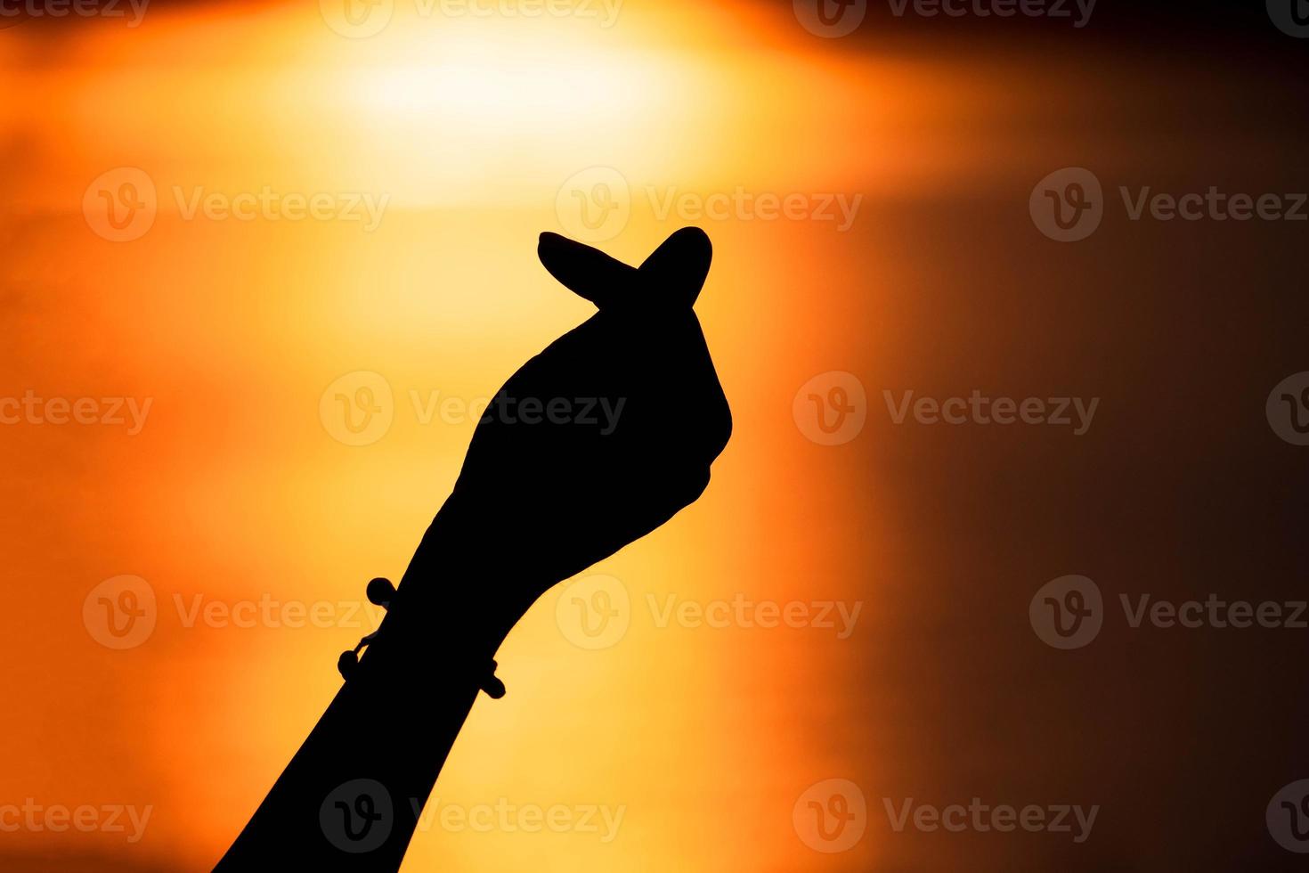 silhouette main en forme de mini coeur avec coucher de soleil, concept d'amour. Joyeuse saint Valentin photo
