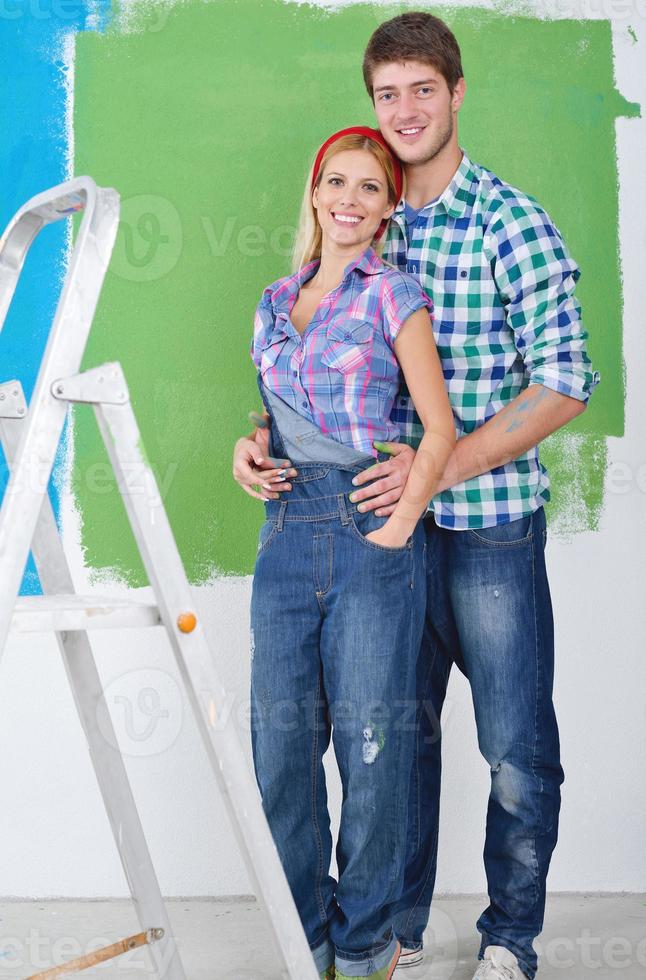 couple heureux peindre un mur dans une nouvelle maison photo