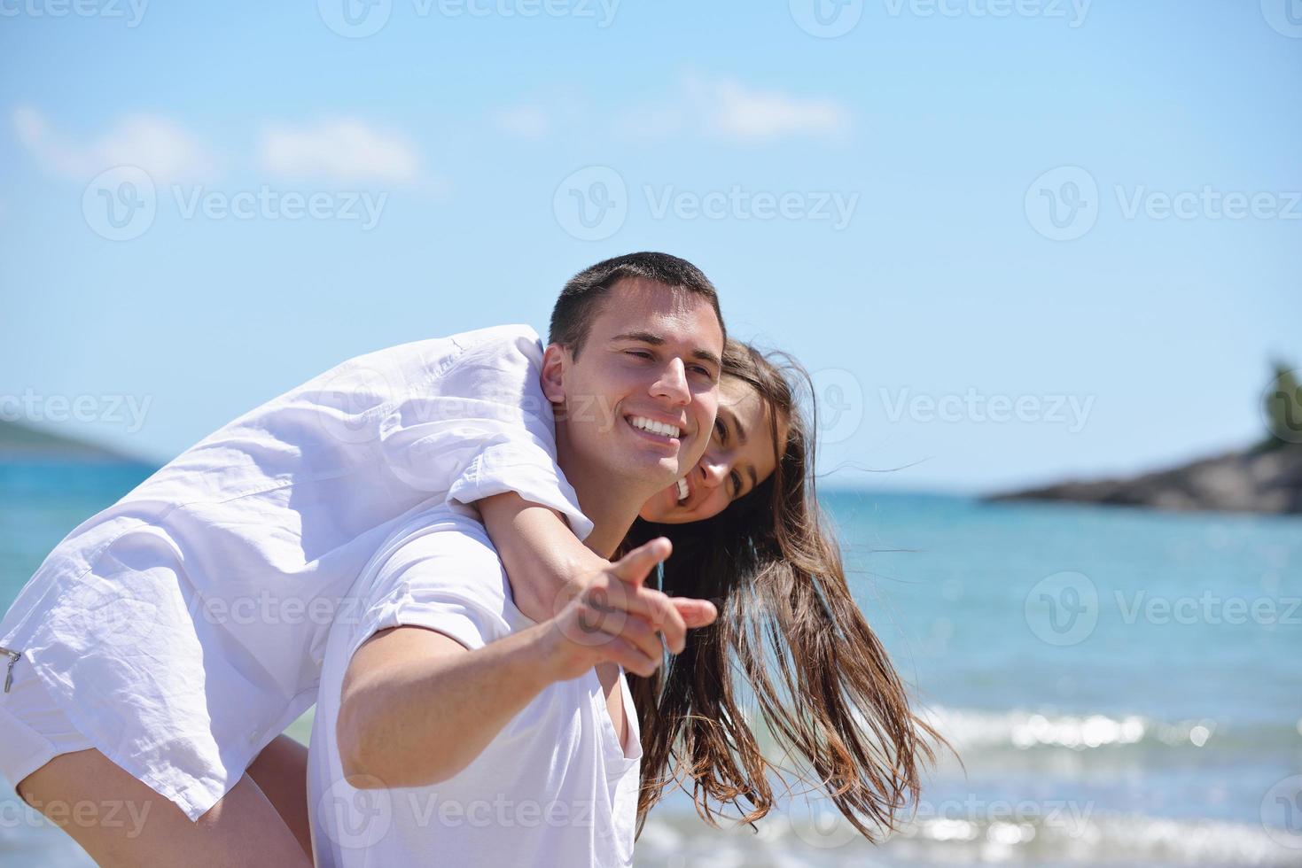 heureux jeune couple s'amuser sur la plage photo