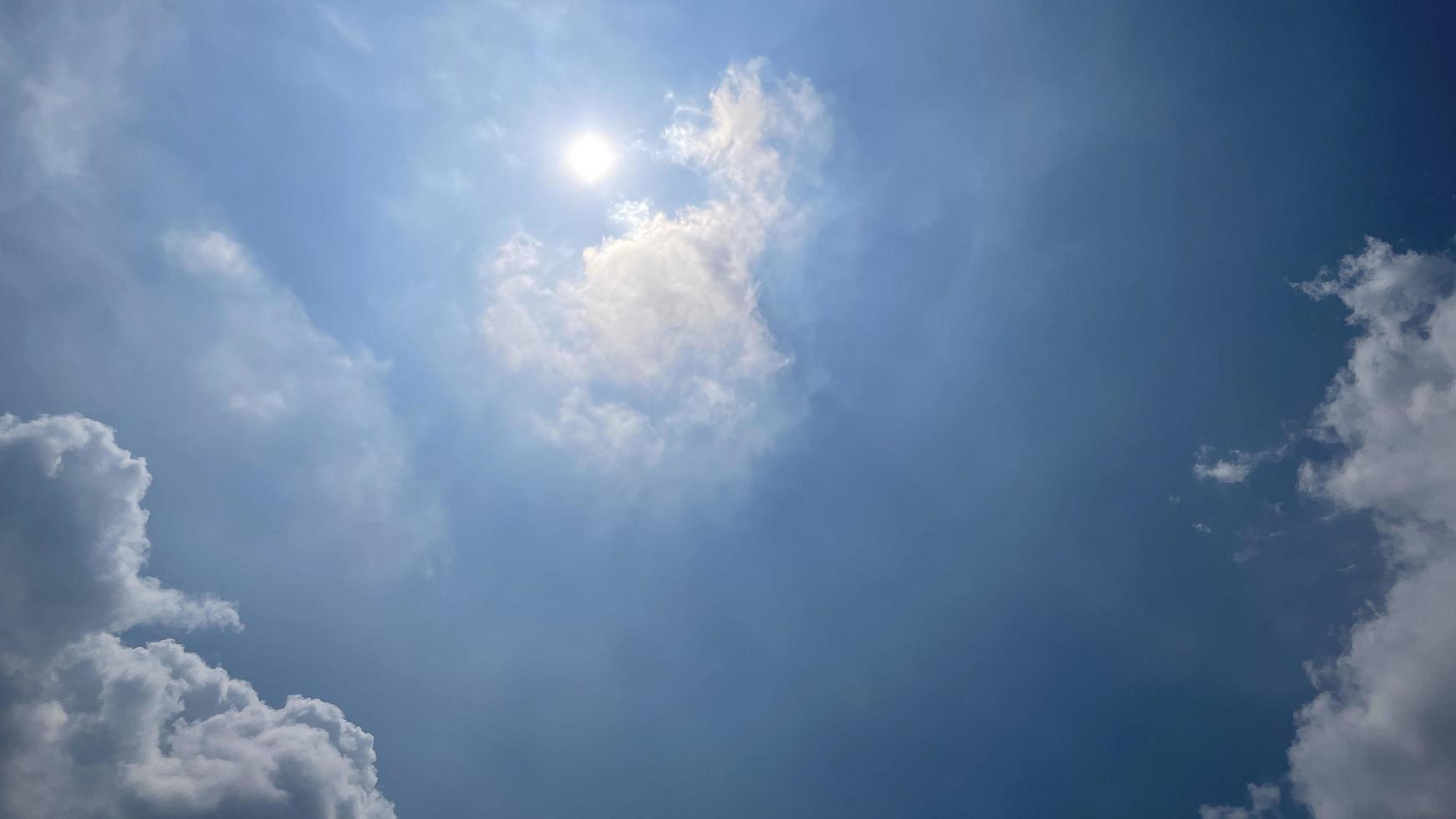 des nuages blancs célestes sur le ciel bleu avec le soleil sont apparus photo