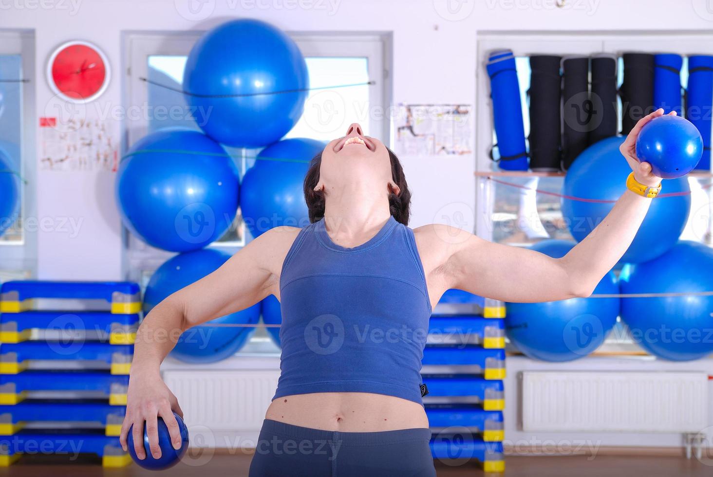 .heureuse jeune femme faisant de l'exercice dans une salle de sport photo