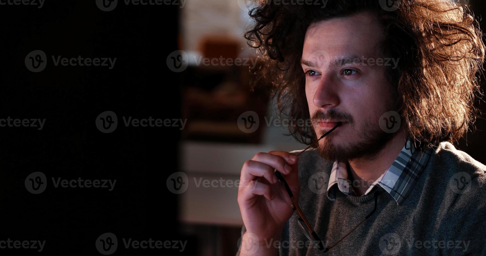 homme travaillant sur ordinateur dans un bureau sombre photo