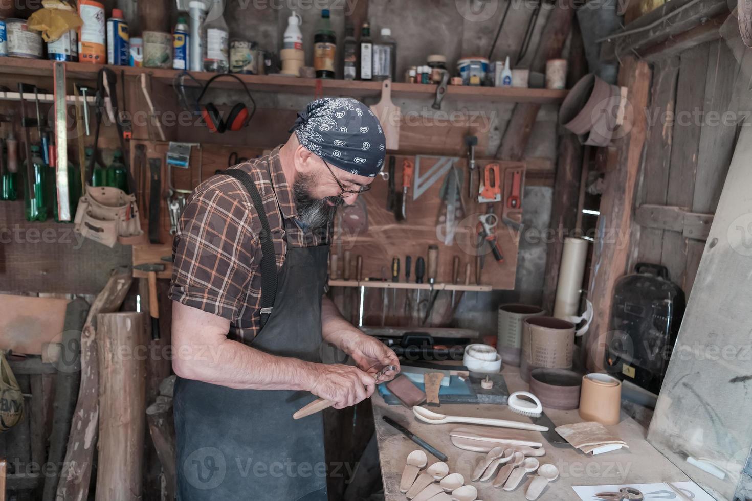 maître cuillère dans son atelier avec des produits et des outils en bois photo