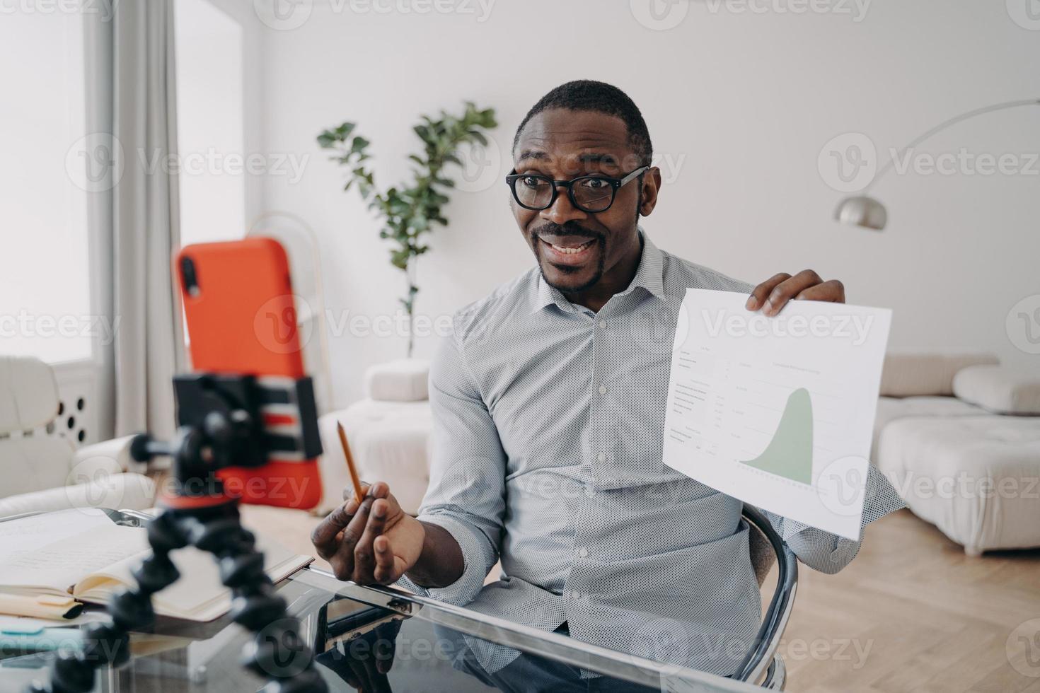 homme d'affaires afro-américain montrant un graphique de données à des collègues via un appel vidéo en ligne sur un smartphone photo