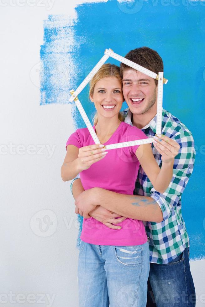 couple heureux peindre un mur dans une nouvelle maison photo