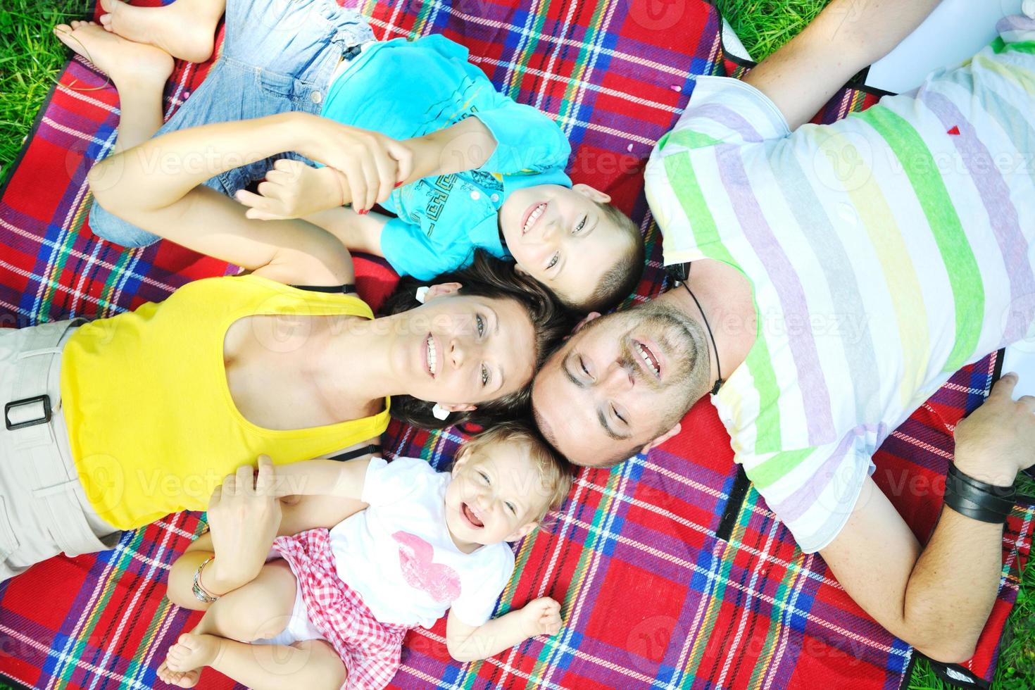 heureux jeune couple avec leurs enfants s'amuser au parc photo