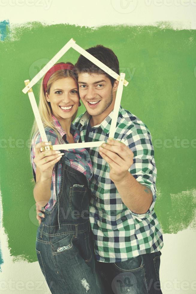 couple heureux peindre un mur dans une nouvelle maison photo