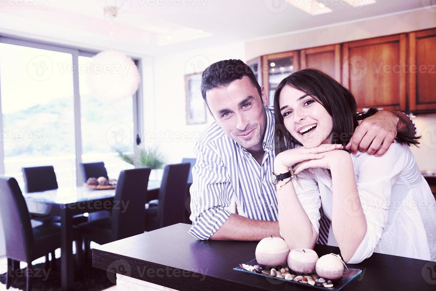 un jeune couple heureux s'amuse dans une cuisine moderne photo