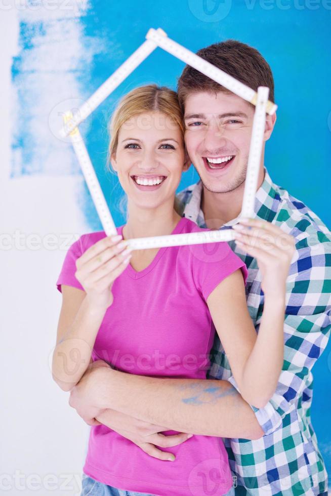 couple heureux peindre un mur dans une nouvelle maison photo